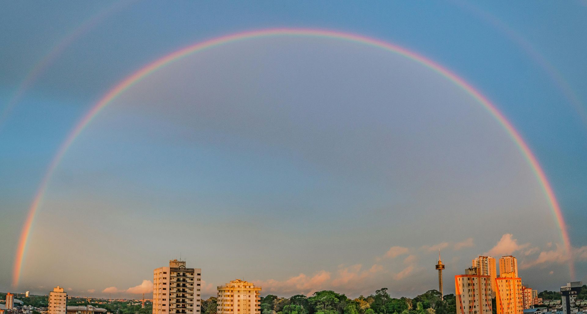 Rainbow over cityscape symbolising diversity inclusion and equity